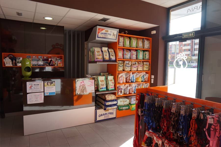 Un consultorio veterinario con un mostrador y estantes llenos de comida para perros y correas.