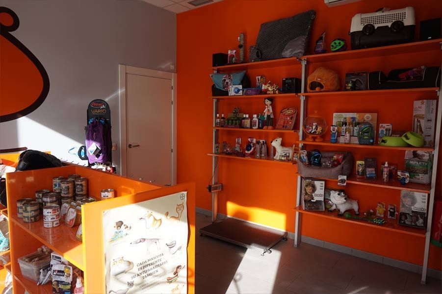 Una habitación con paredes naranjas y estantes llenos de artículos para mascotas.