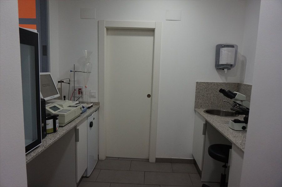Una habitación con un microscopio y una computadora en el mostrador.