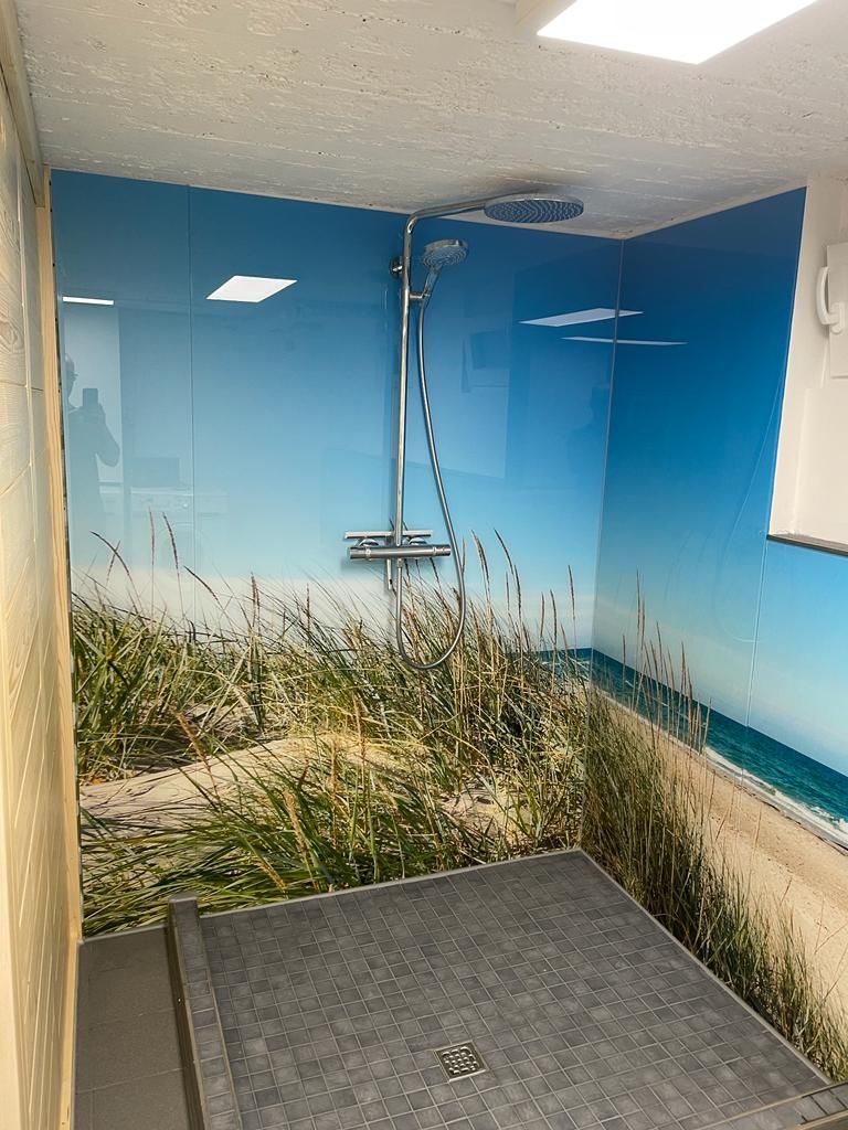 ein Badezimmer mit einer Dusche aus Motivglas