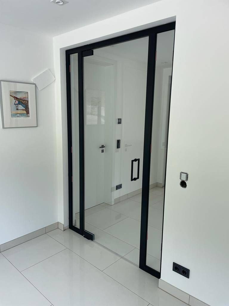 ein Raum mit weißen Wänden und einer Glasschiebetür .