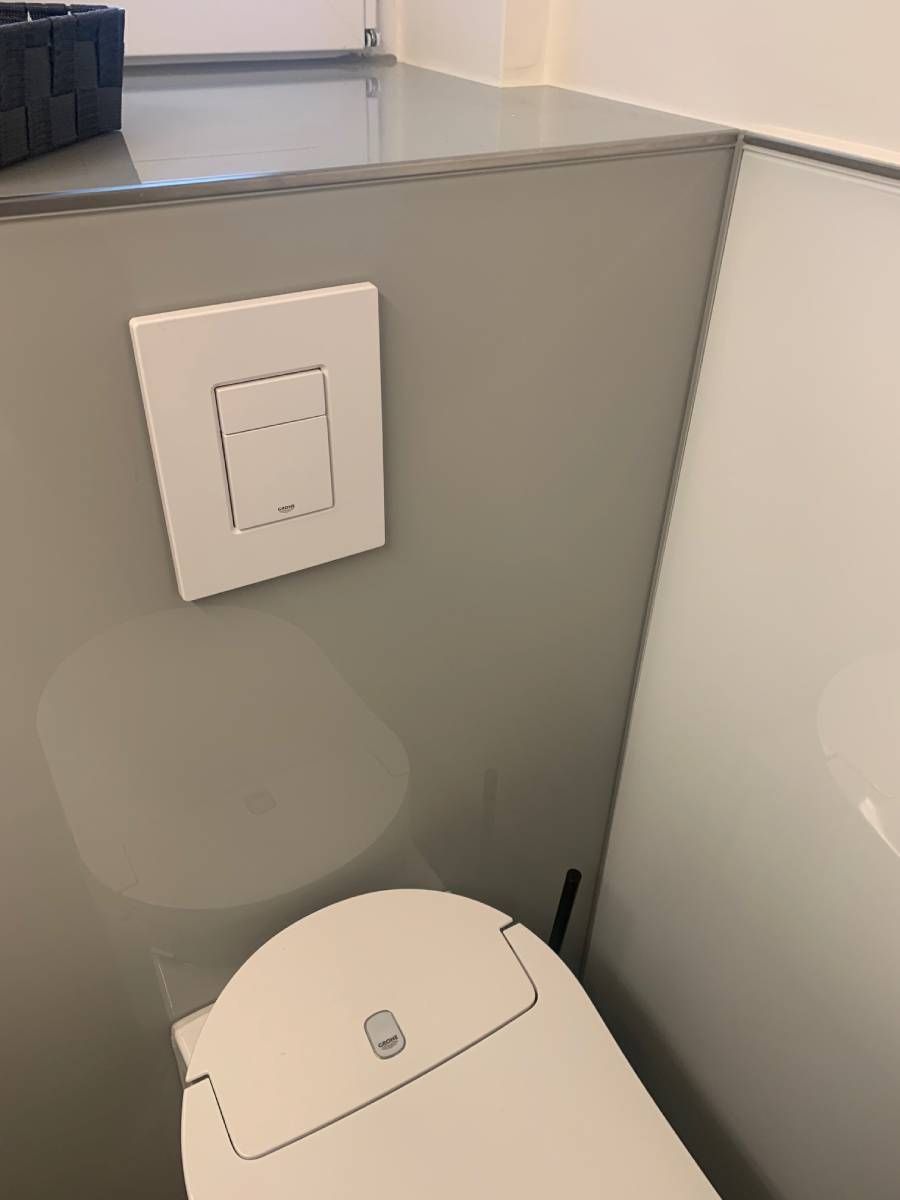 Glasrückwand einer Toilette