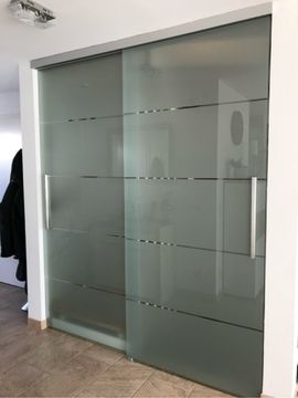 eine Schiebetür aus satiniertem Glas in einem Raum .