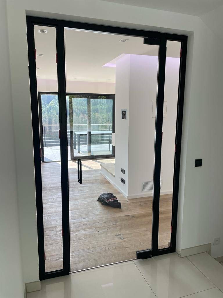 eine Glasschiebetür führt in ein Wohnzimmer .