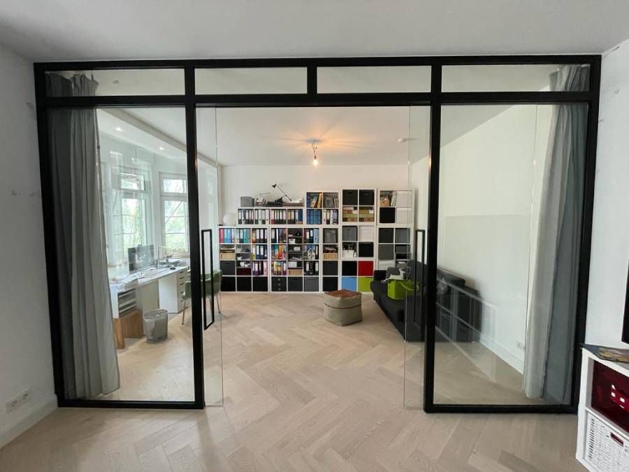 ein Wohnzimmer mit Glasschiebetüren und einem Bücherregal .