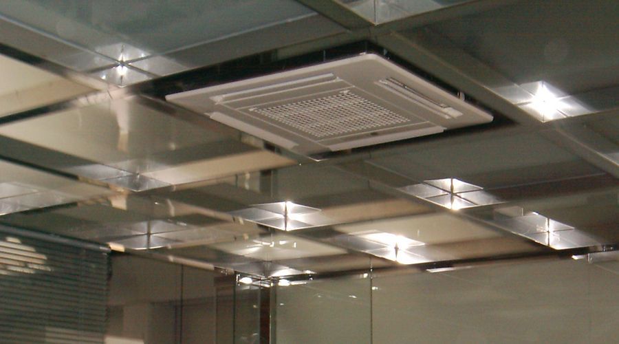 Techo reflectante de oficina con luces empotradas y un panel de ventilación central.