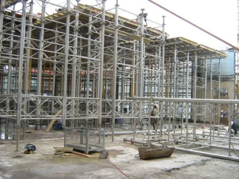 Eine Baustelle, auf der ein Stahlgerüst die Schalung für eine neue Gebäudedecke stützt.