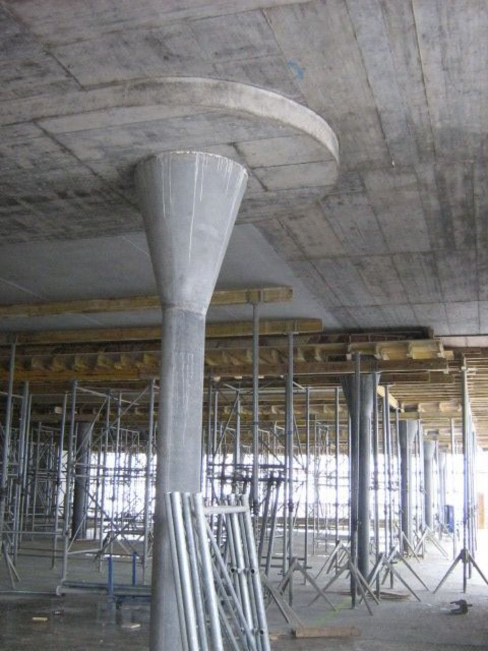 Eine Betondeckenplatte, die von ausladenden, pilzförmigen Säulen in einem im Bau befindlichen Gebäude getragen wird.