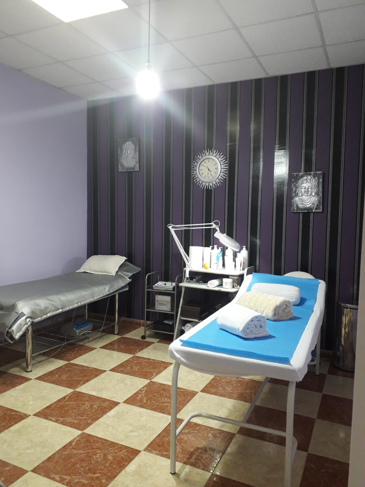 Una habitación con dos camas y suelo de cuadros.