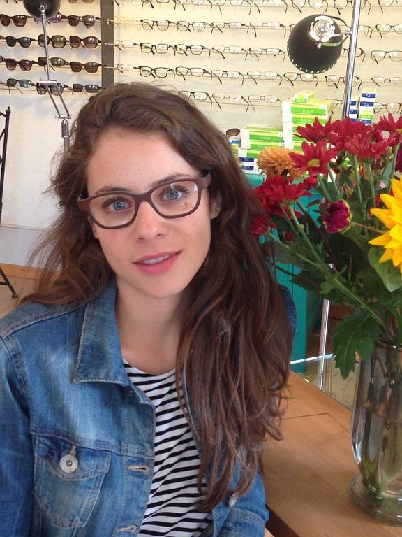 Pauline avec une monture de la nouvelle collection en bois	