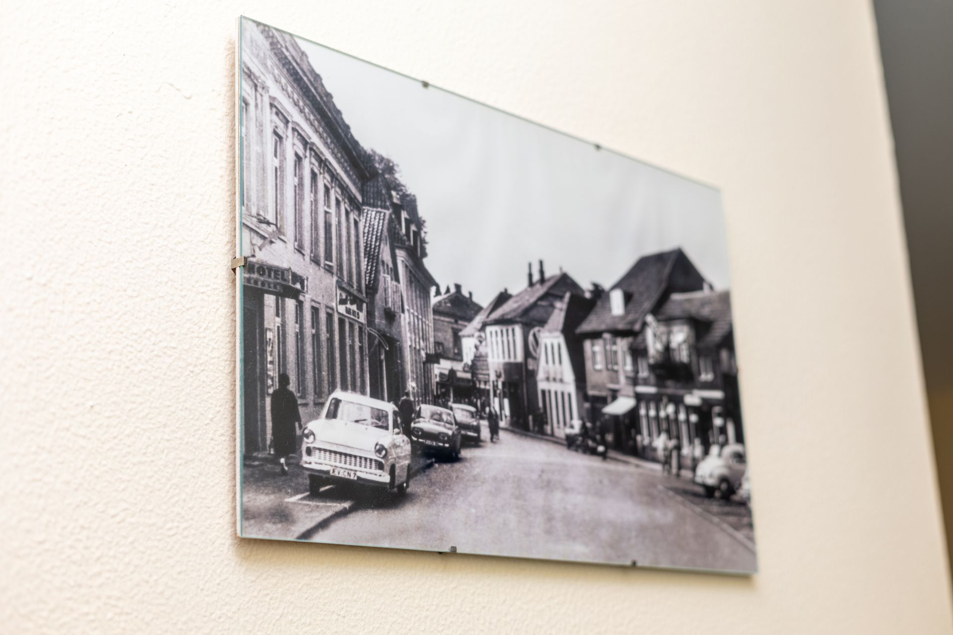 An einer Wand hängt ein Schwarzweißfoto einer Stadtstraße.