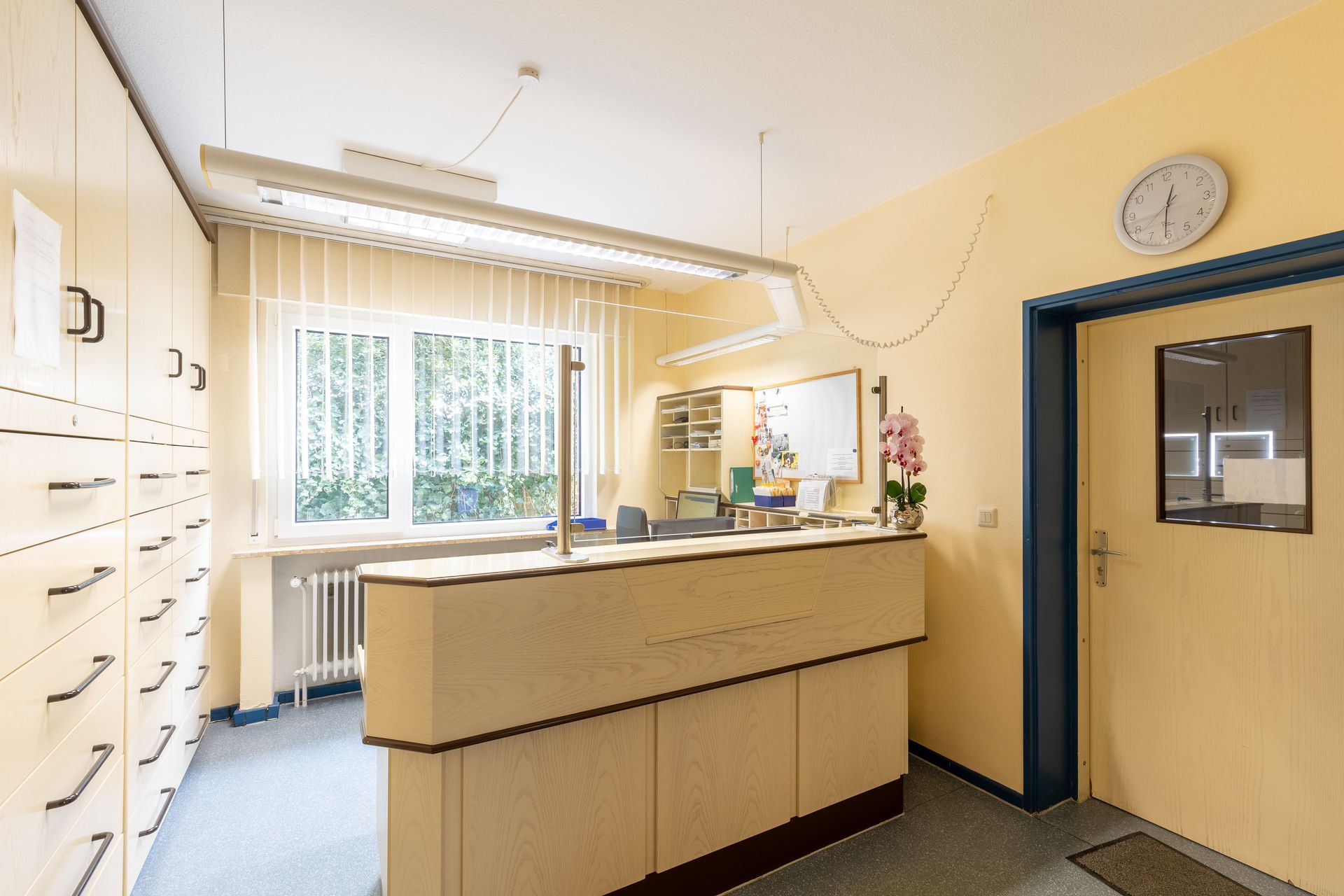 Ein Empfangsbereich in einem Krankenhaus mit einer Uhr an der Wand.