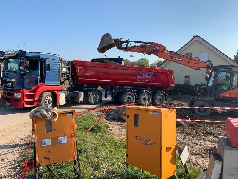 Bagger belädt LKW auf einer Baustelle