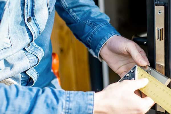 Un hombre está midiendo una puerta con una cinta métrica.