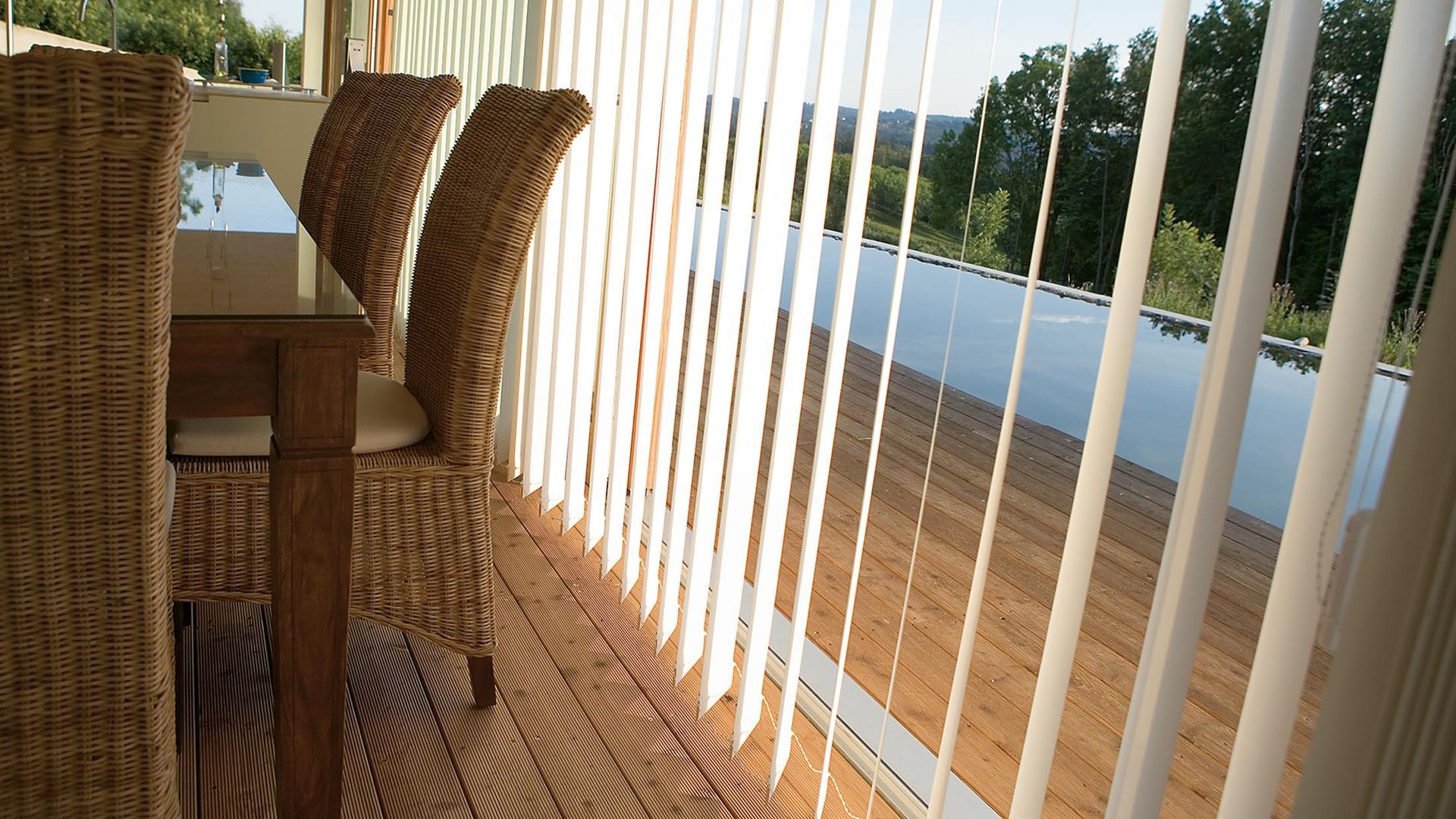 Ein Tisch und Stühle auf einem Balkon mit Blick auf einen Swimmingpool
