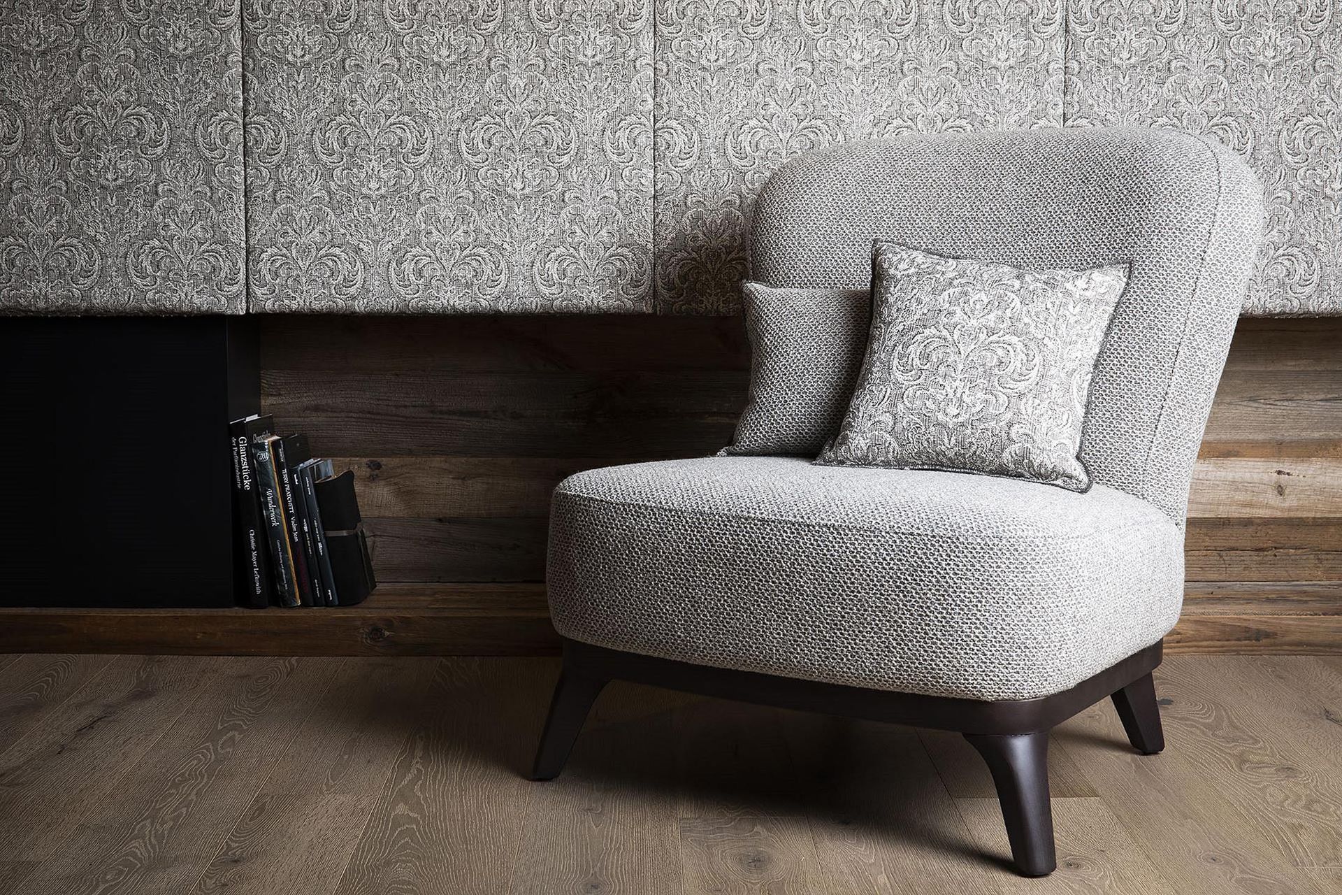 Ein Stuhl mit zwei Kissen darauf steht in einem Raum neben einem Kamin.