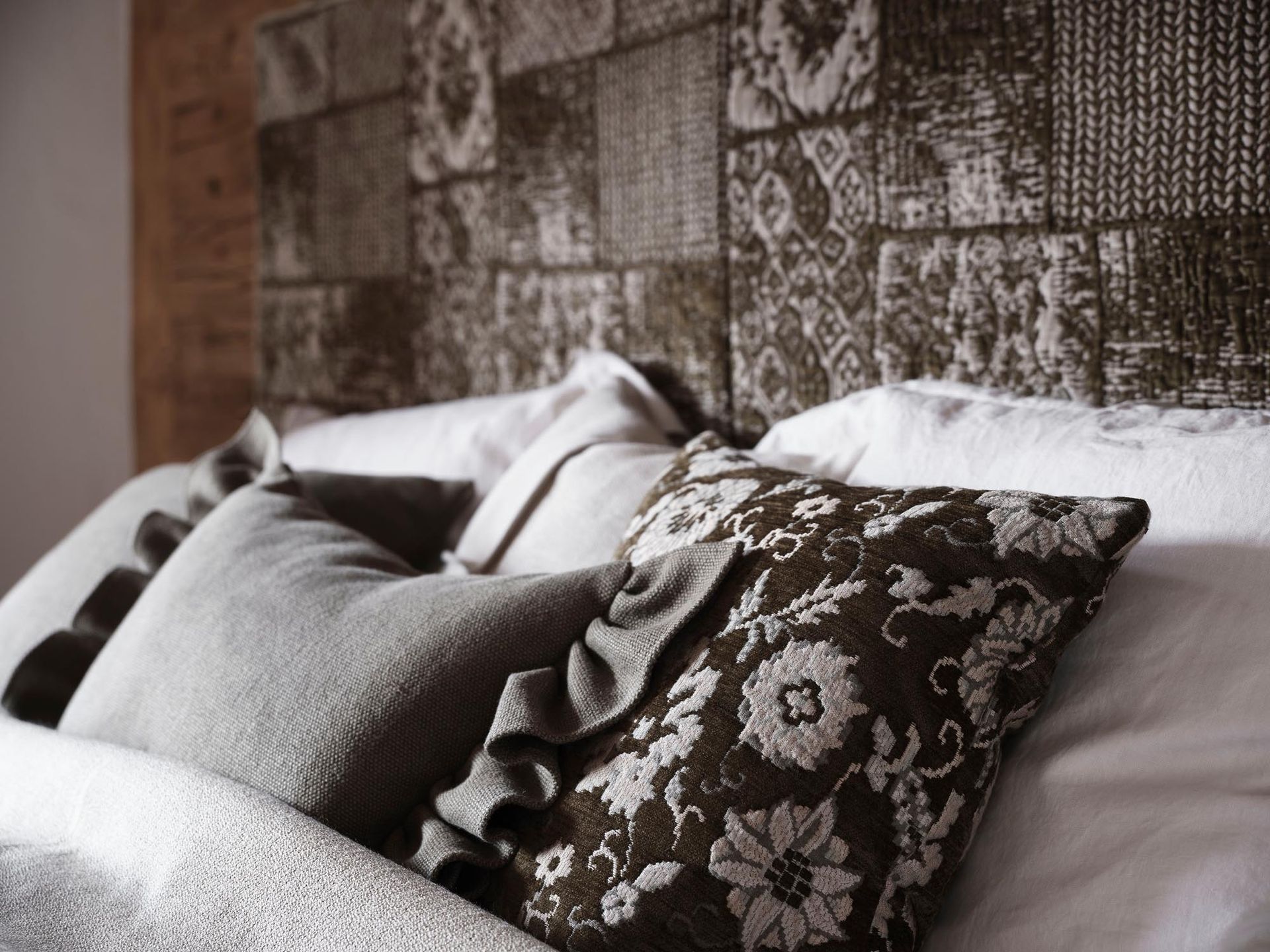 Ein Bett mit einer Decke und Kissen darauf.