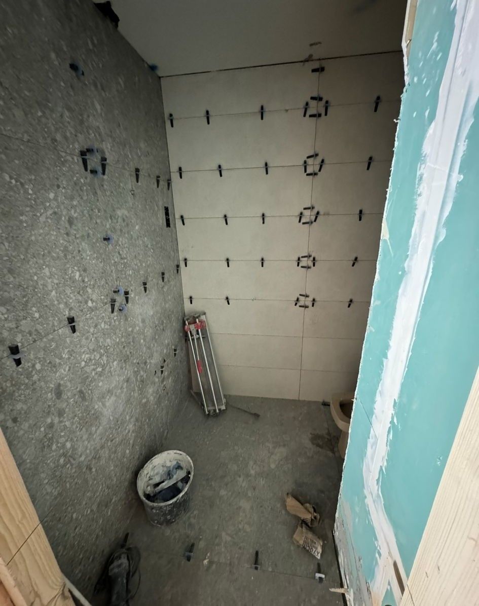 Un baño en construcción con un balde de cemento en el suelo.