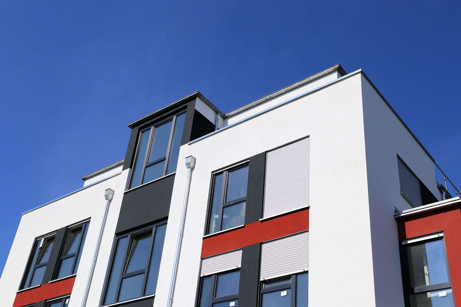 Un edificio blanco y rojo con un cielo azul de fondo.