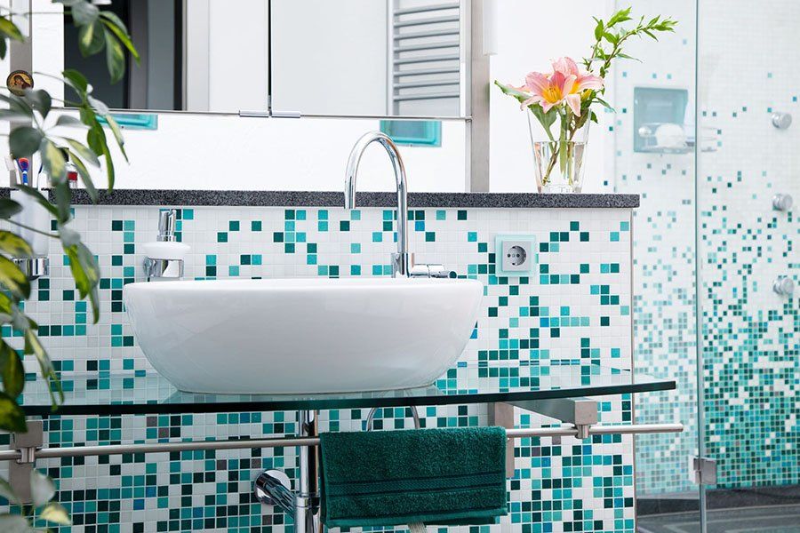 Sable de bains avec un carrelage mural en mosaïque dans les tons blanc et bleu