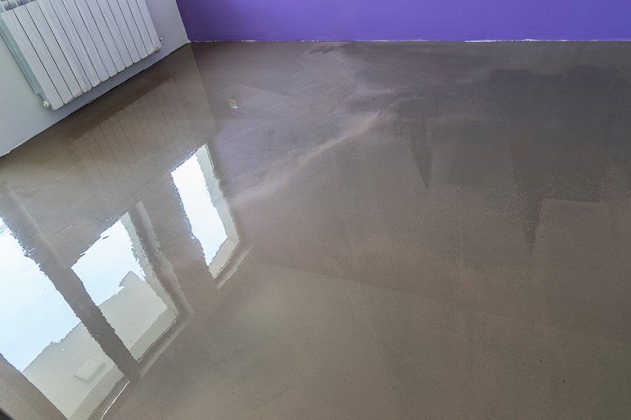 Sol d'une pièce au mur violet recouvert d'une chape fluide