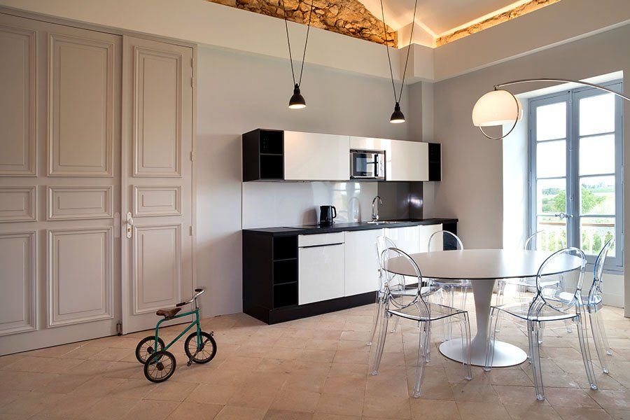 Grande cuisine moderne noir et blanc avec une table et six chaises transparentes