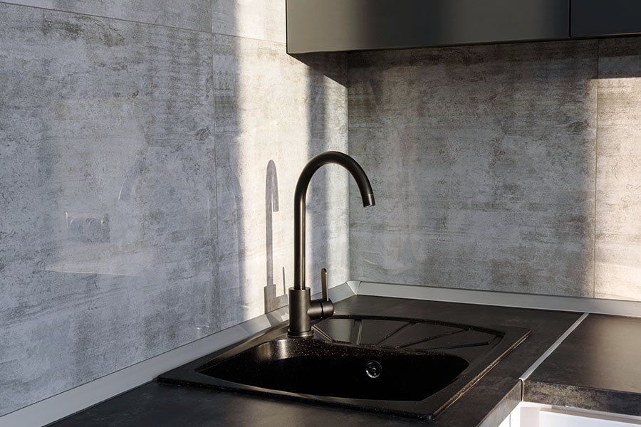 Évier de cuisine noir avec murs carrelés gris clair