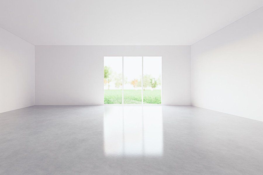 Intérieur d'une pièce vide à la chape claire et lisse et aux murs blancs