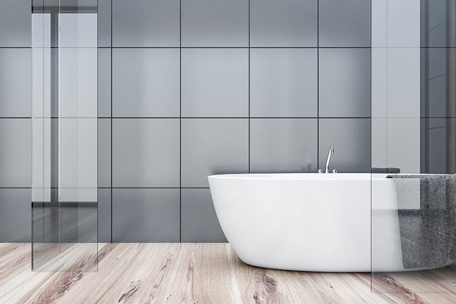 Salle de bains avec baignoire et grands carreaux de carrelage gris sombre au mur