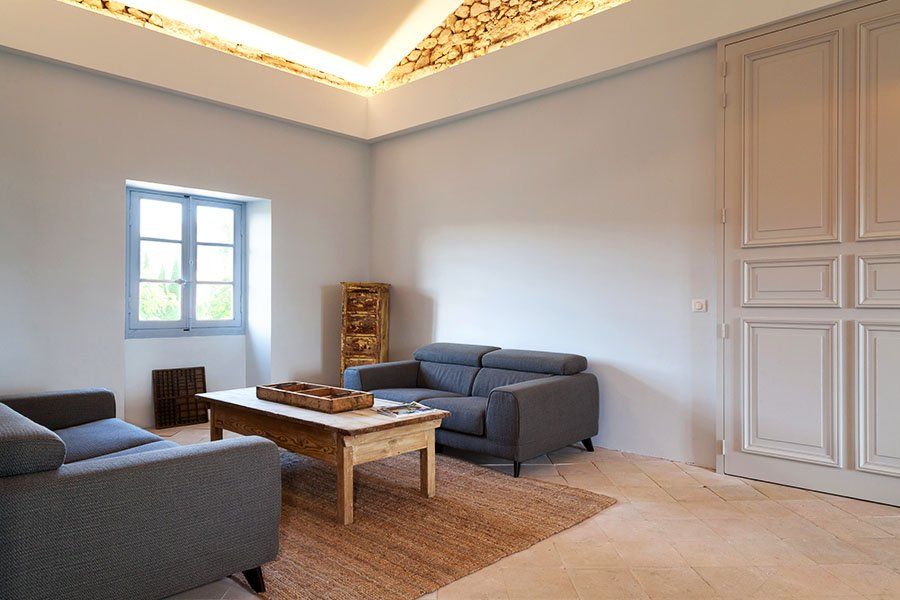 Grand salon moderne avec deux canapés gris et une table basse en bois