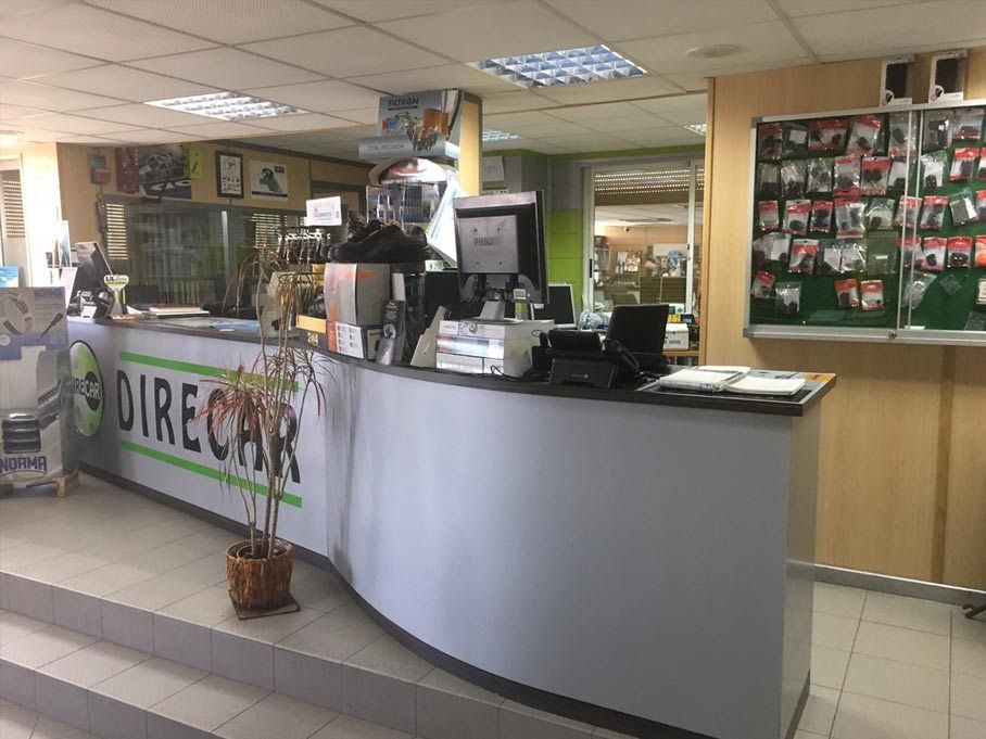 Un mostrador de recepción en una tienda con una planta encima.