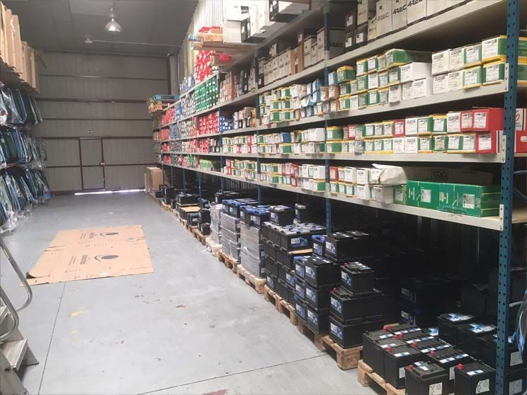Un almacén lleno de muchos estantes y palés de baterías.
