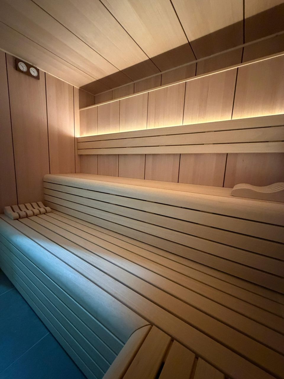 Banc de sauna en panneaux de bois avec rétroéclairage chaleureux et intérieur en lattes de bois