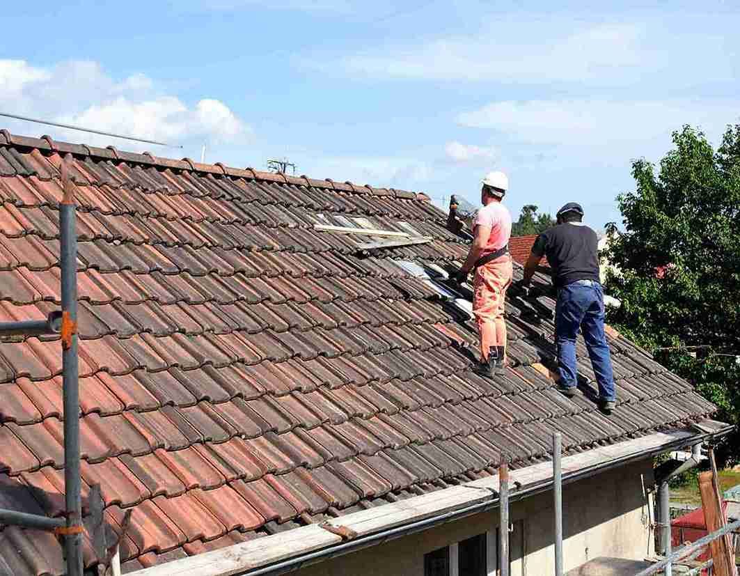 Obreros de la construcción dentro de un apartamento con andamios, herramientas y grandes ventanales; tonos neutros.
