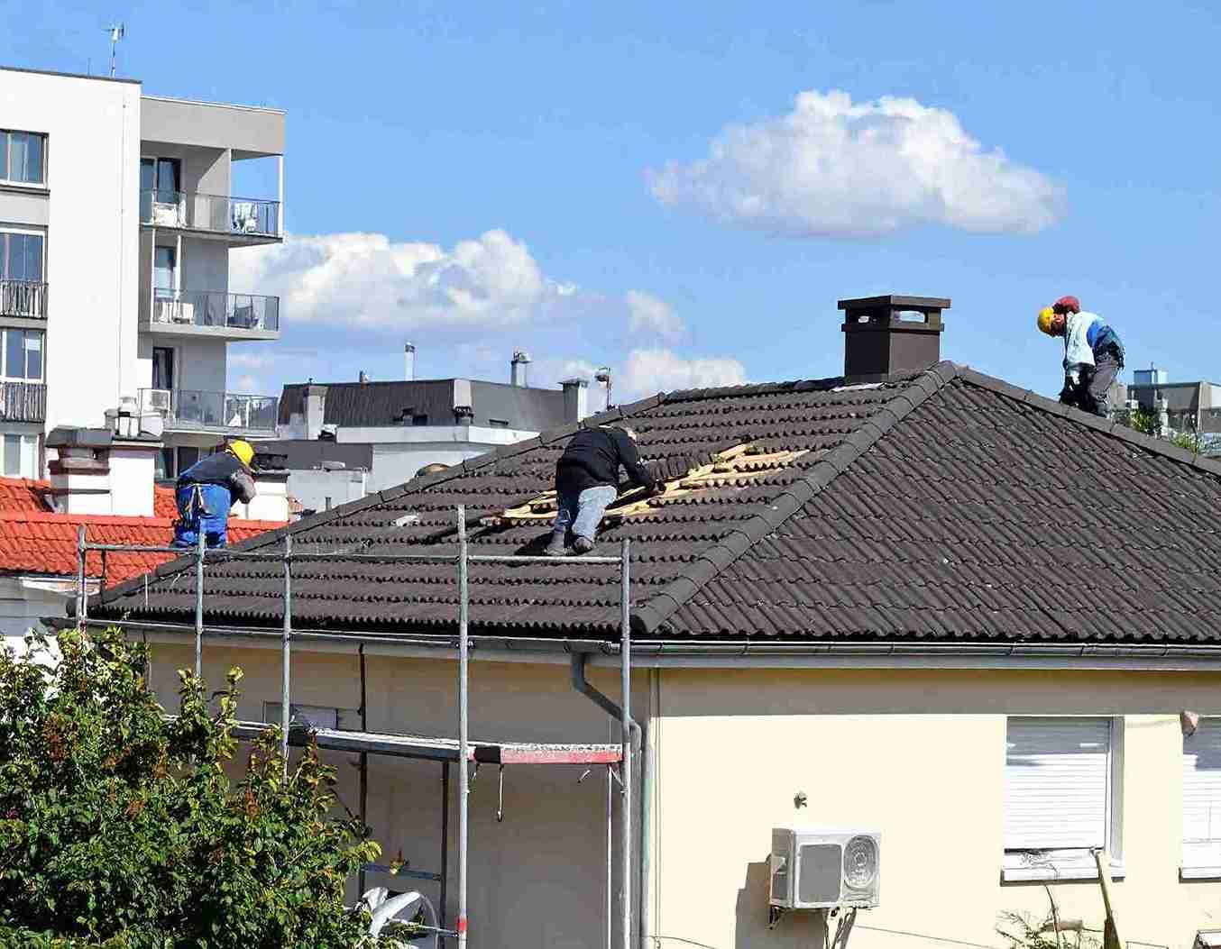 Persona que utiliza una paleta para aplicar mortero a una pared de ladrillos rojos.