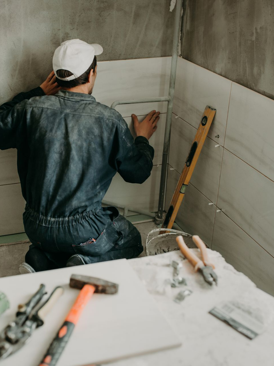 Une personne pose du carrelage.