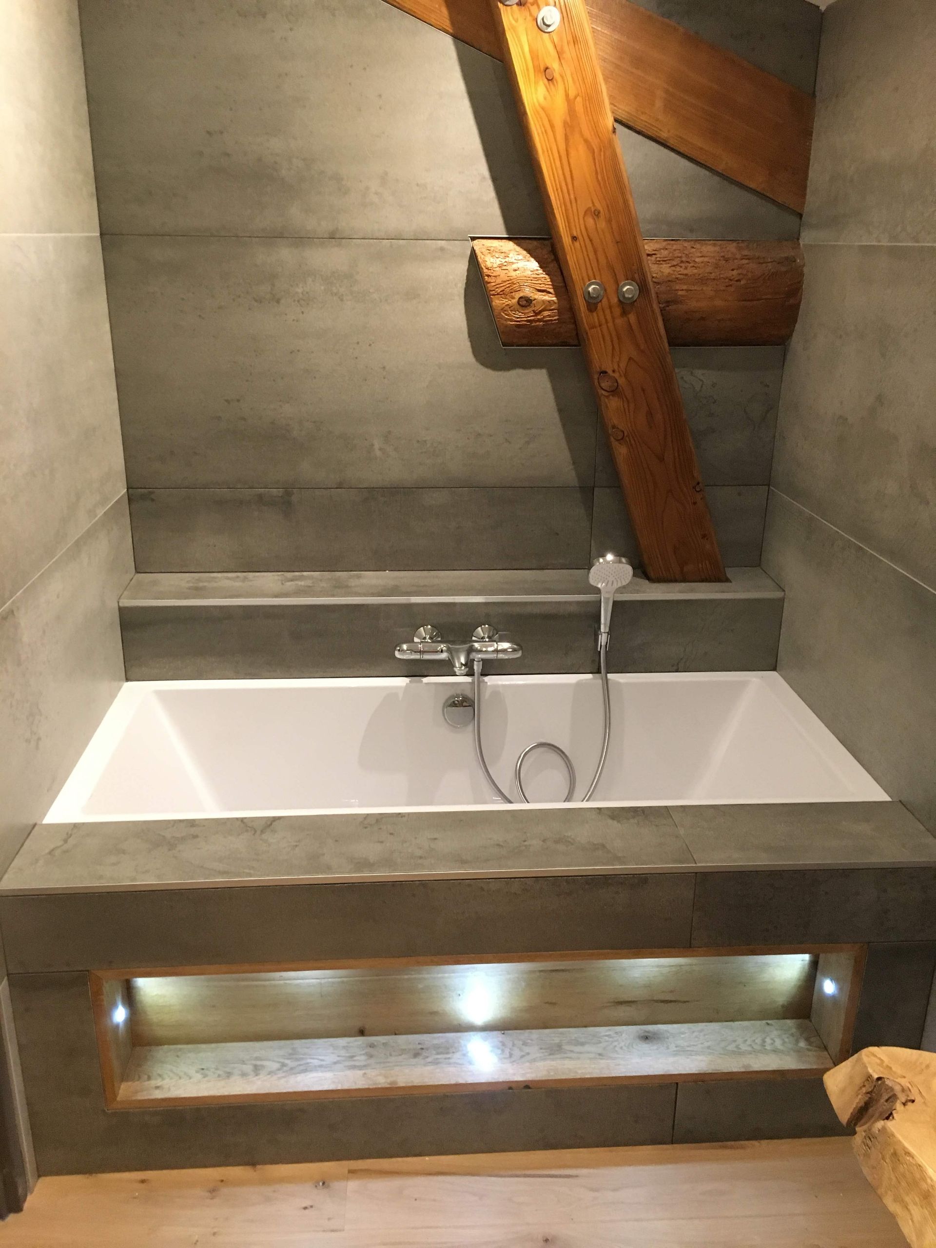 Salle de bains moderne avec miroir rond, meuble lavabo en bois.