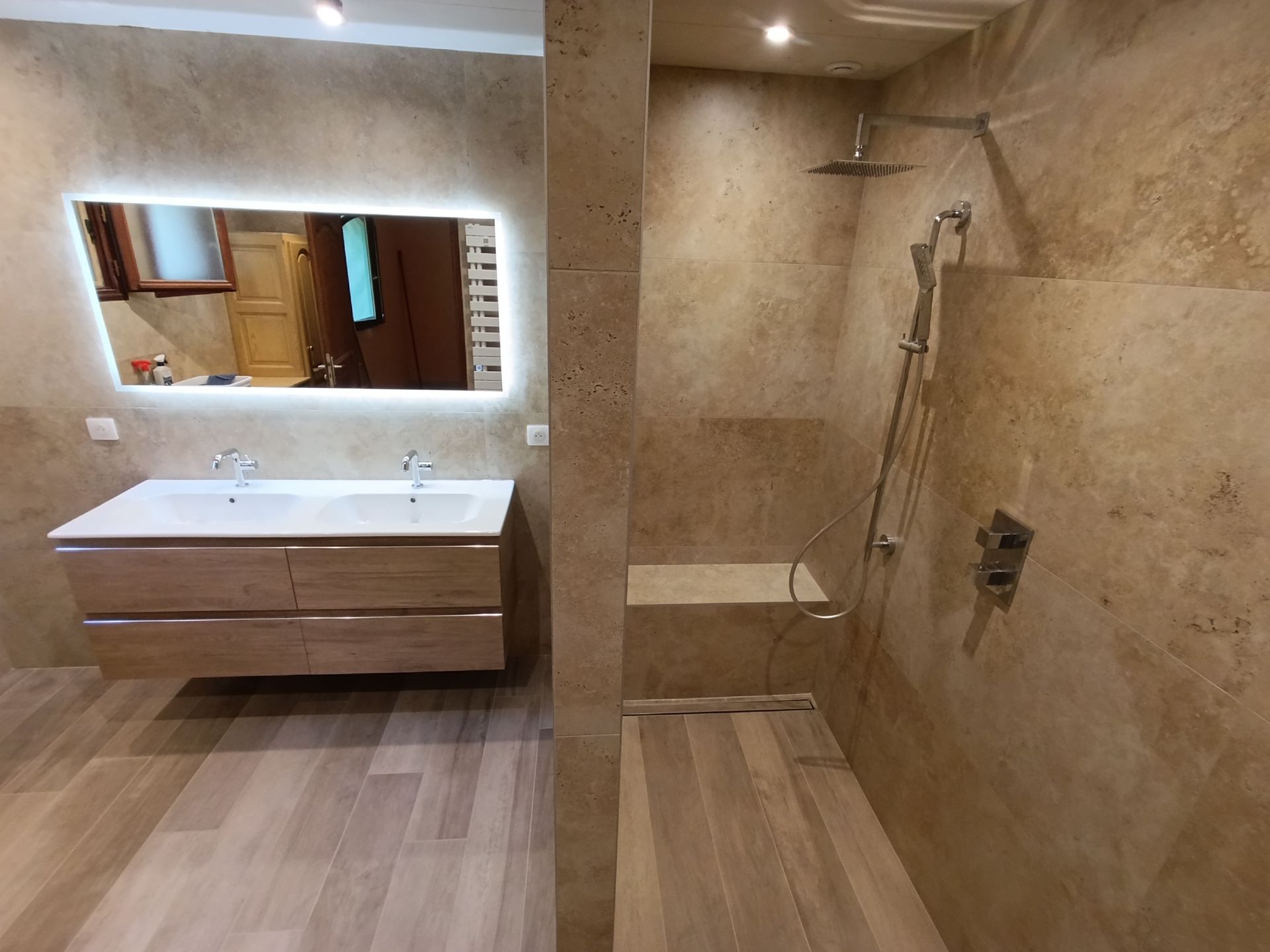 Salle de bains moderne avec douche à l'italienne, meuble-lavabo double vasque et éléments en bois clair.