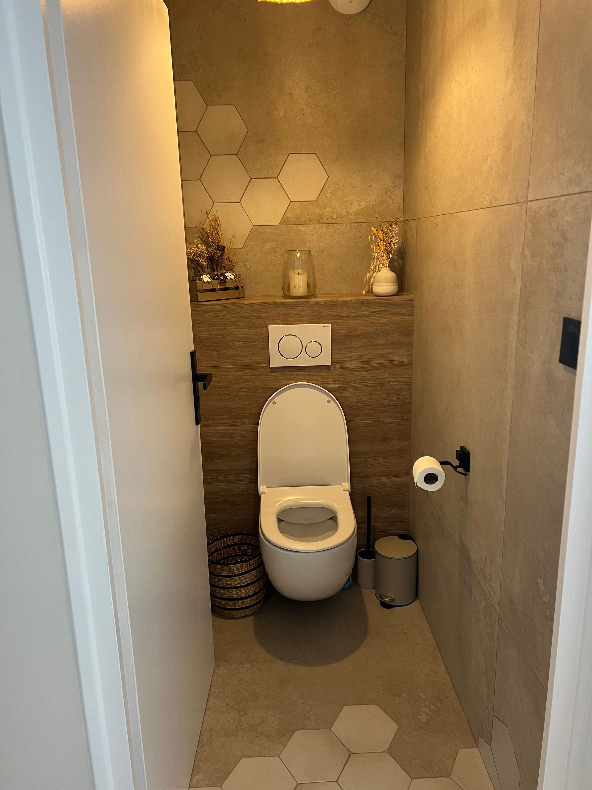Une petite salle de bains avec toilettes, murs en pierre et accents de carrelage en nid d'abeille.