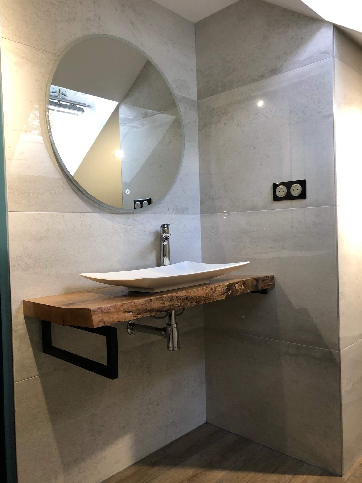 Salle de bains moderne avec lavabo sur une étagère.