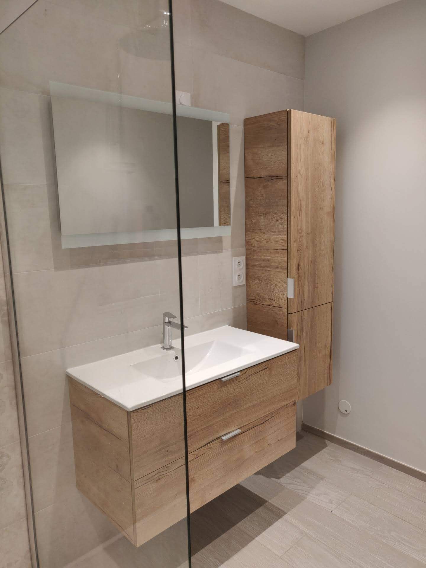 Salle de bains moderne avec meuble lavabo blanc, éléments en bois et baignoire.