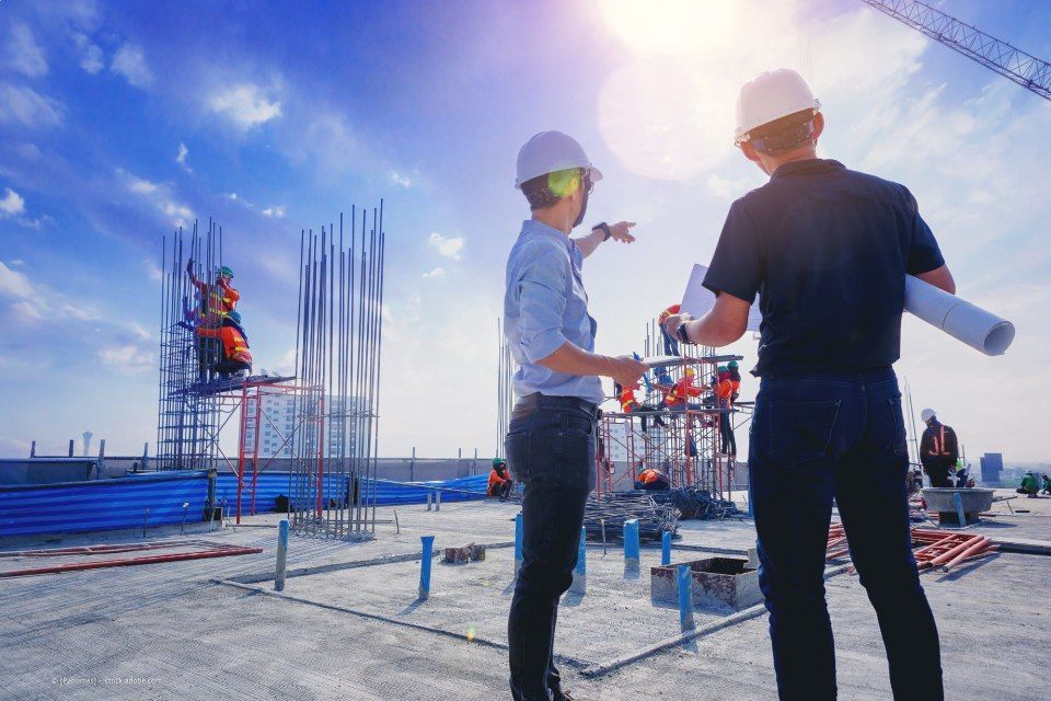 Bauleiter bespricht weiteren Plan auf Baustelle
