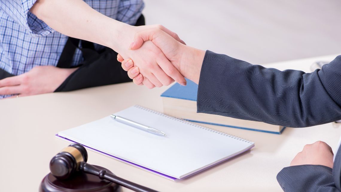 Un hombre y una mujer se dan la mano en una mesa.