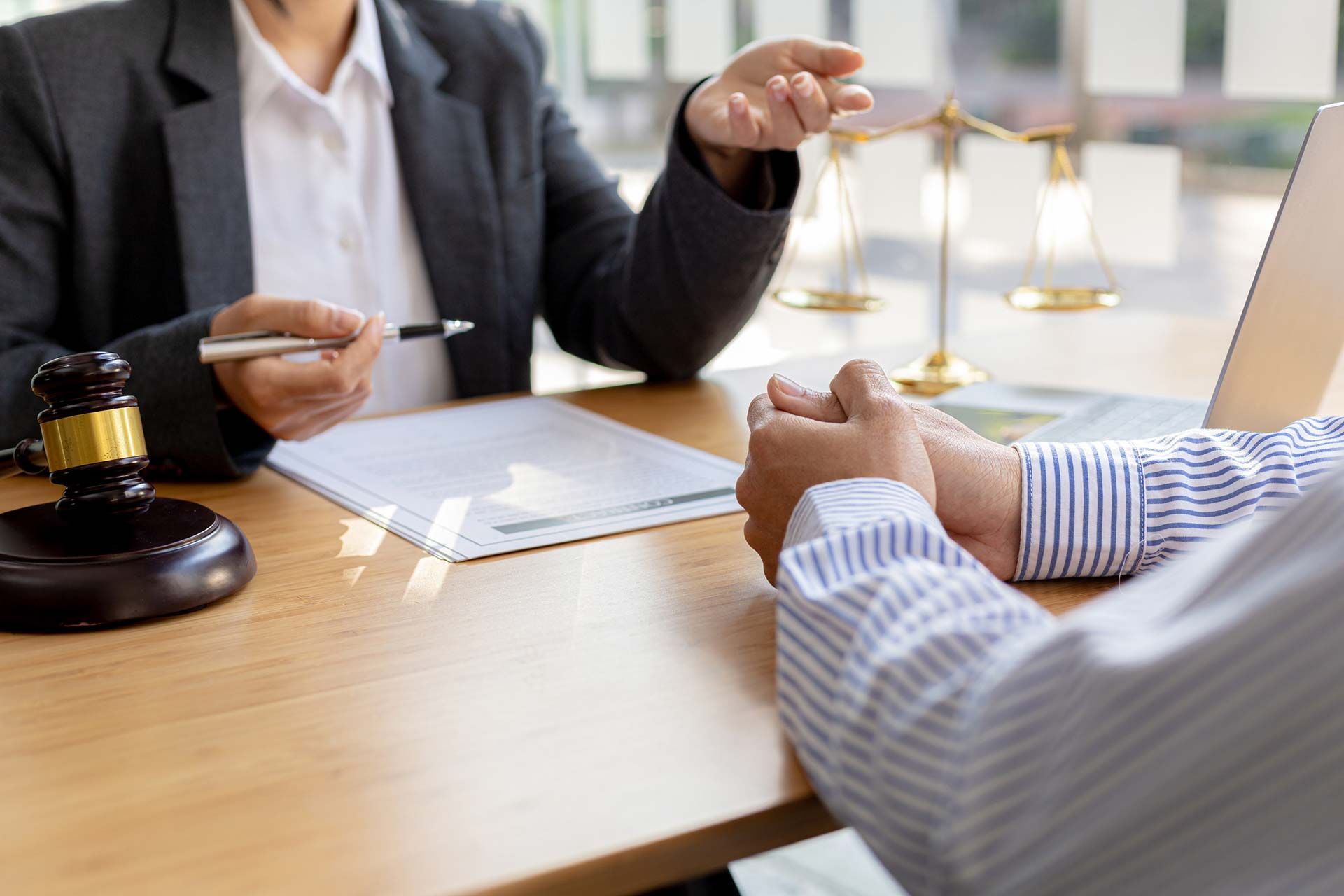 Un abogado discute un caso con un cliente en una sala de audiencias.