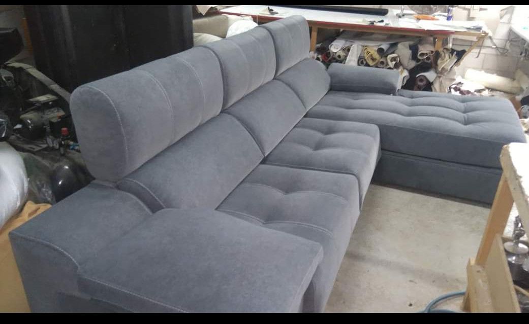 Sofá modular gris en una tienda de muebles, visto de perfil.