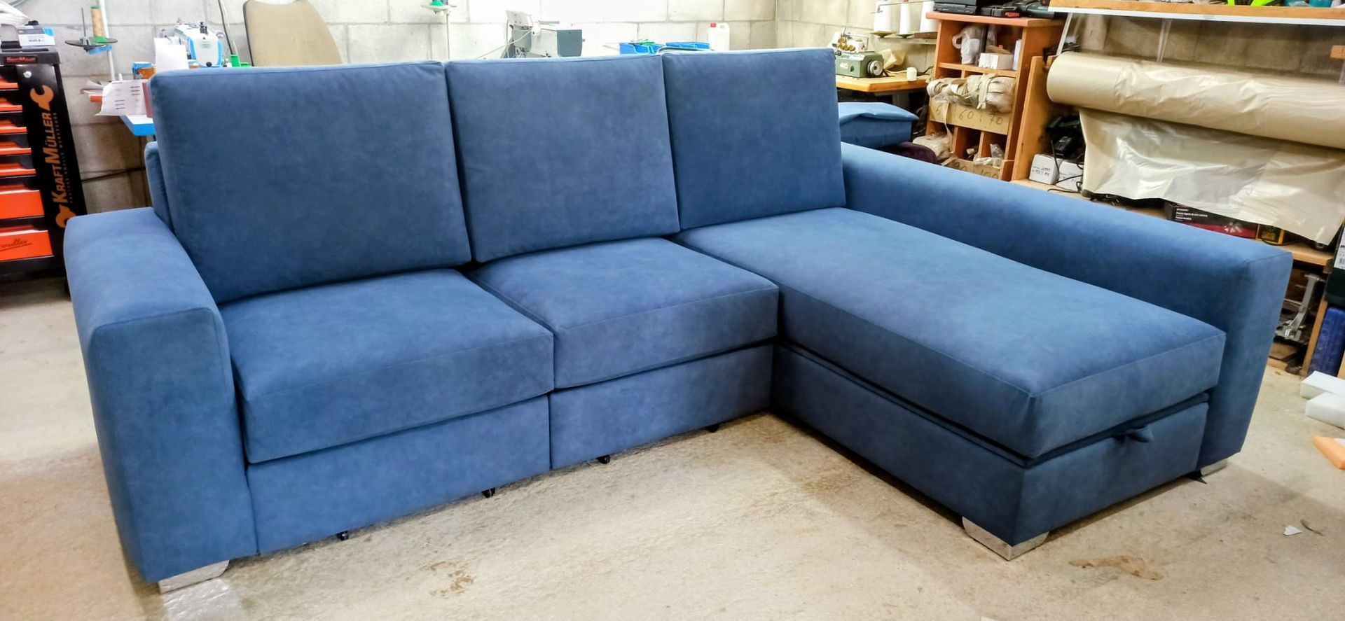 Sofá seccional azul en forma de L en la sala de exposición de una tienda.