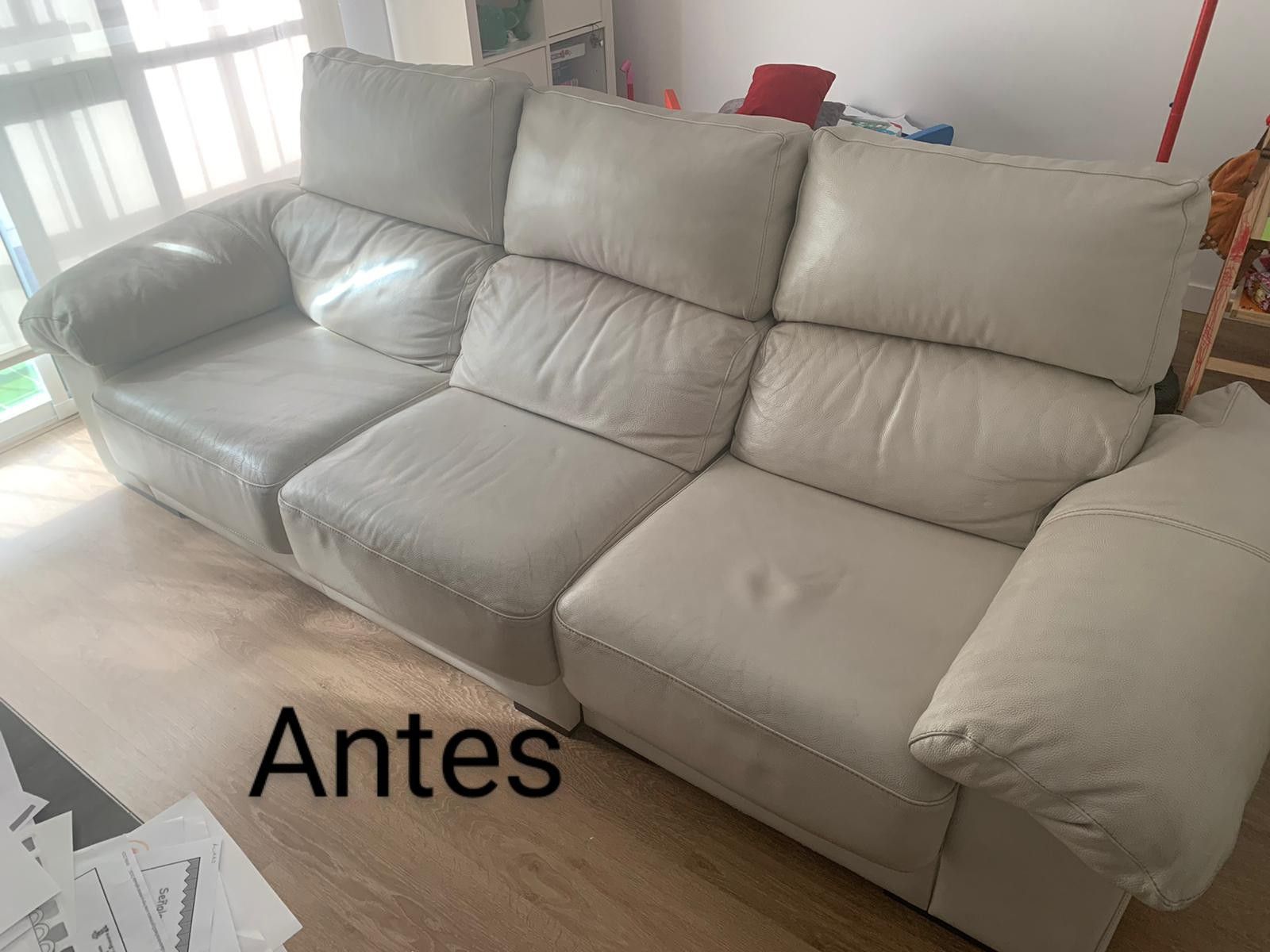 Antes de un sofá blanco de tres plazas en una sala luminosa.