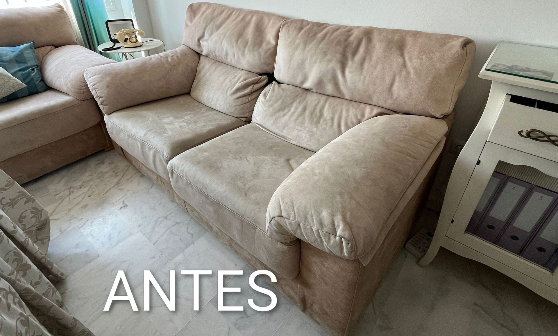 Sofá seccional beige con cojines en una sala de estar, con la etiqueta “ANTES” en la parte inferior.