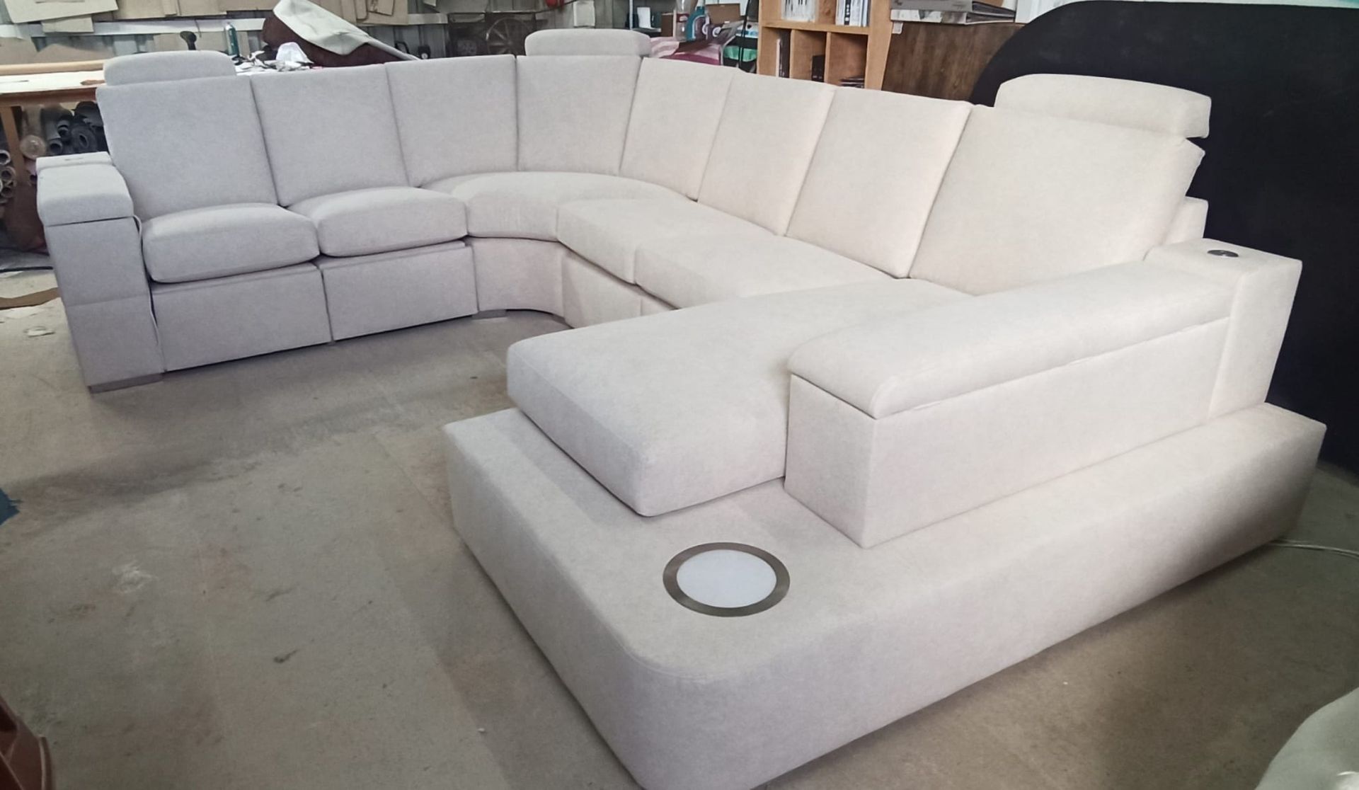 Sofá seccional blanco en forma de L con sillón reclinable incorporado en una exposición de muebles.