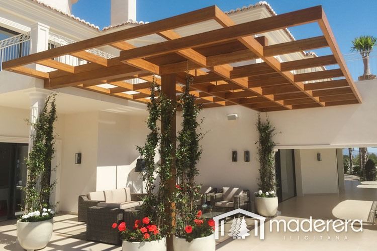 Una gran casa blanca con una pérgola de madera encima.